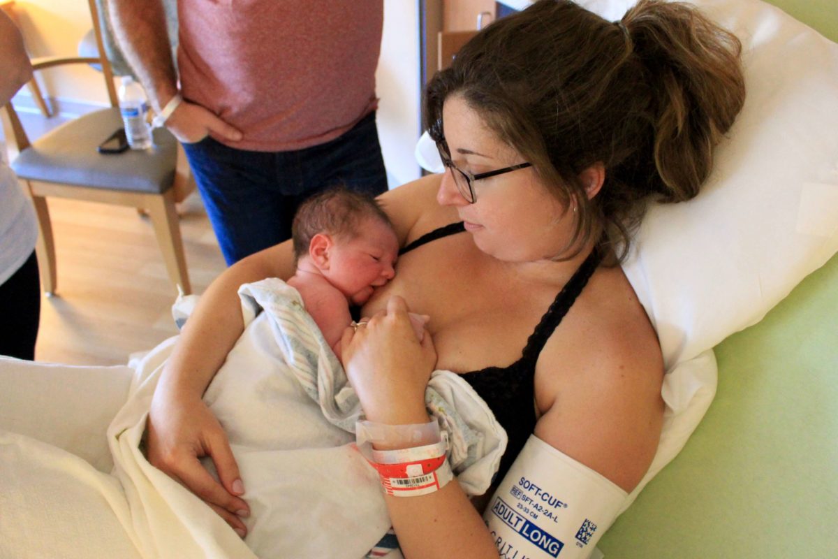 Mother in a hospital bed breastfeeding her newborn baby